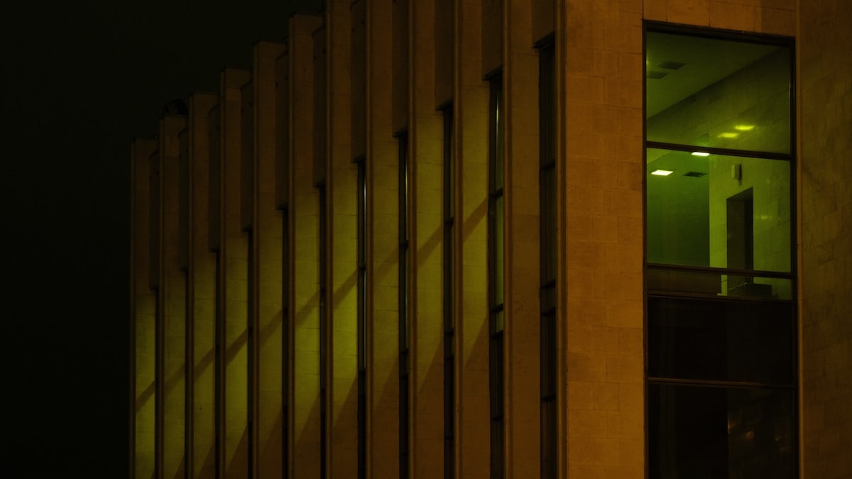 House illuminated at night showing interior through glass walls